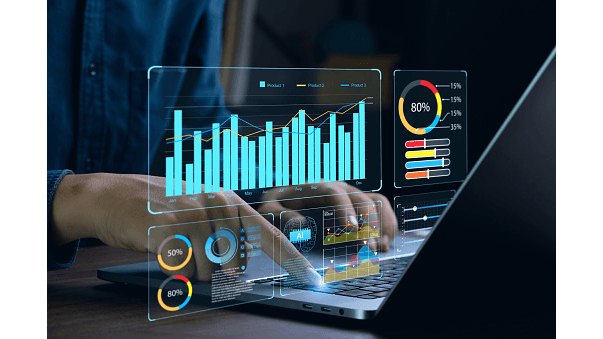 A person's hands working on a laptop displaying holographic analytics and performance charts.