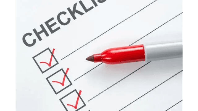 A red pen marking checkboxes on a checklist.