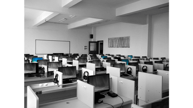 A computer lab with multiple desktop computers and headphones.