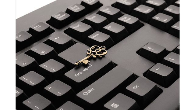 A decorative key rests on a computer keyboard.